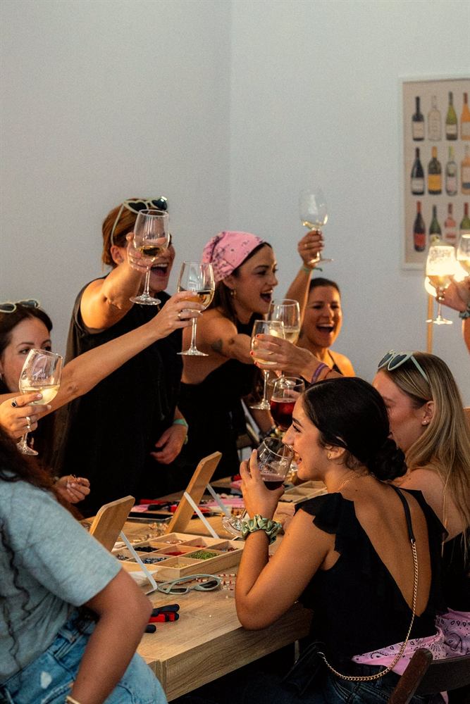 Un grupo de amigas brindando mientras crean sus joyas